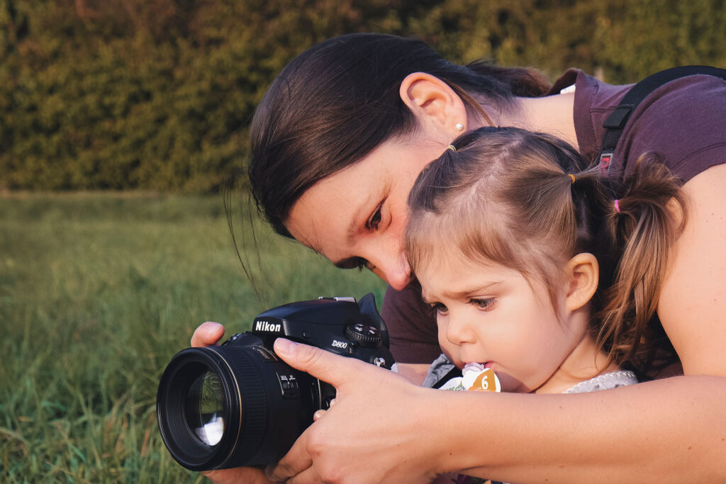 Constanze Pfeifer in einer Fotosession, ein Kind schaut durch die Kamera
